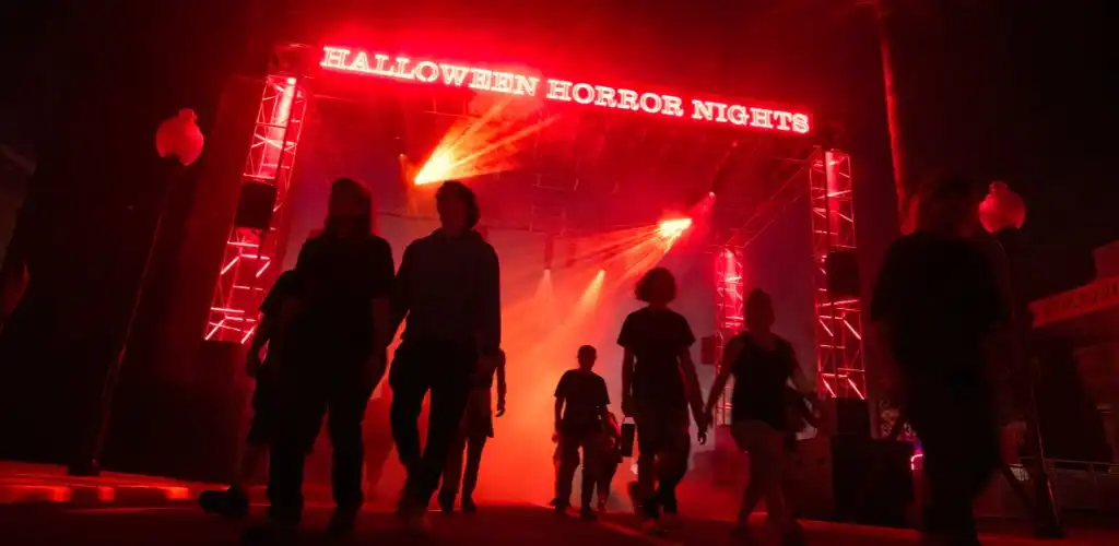 Dark creative shot of guests at the Halloween Horror Nights entrance at Universal Studios Florida.