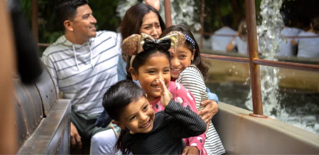 A family enjoying a boat ride together outdoors with smiling children and adults, surrounded by water and nature.