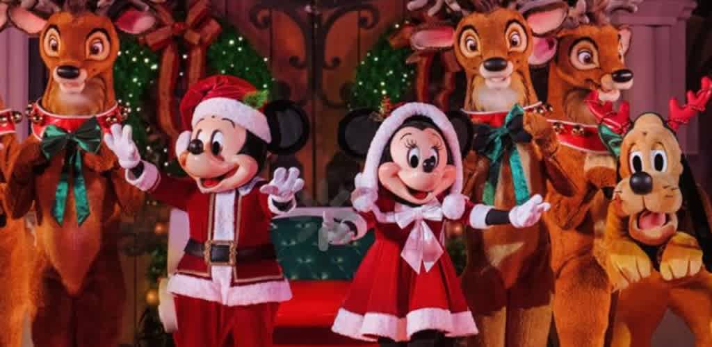 Disney characters dressed in holiday outfits surrounded by reindeer and Christmas decorations at a festive celebration.