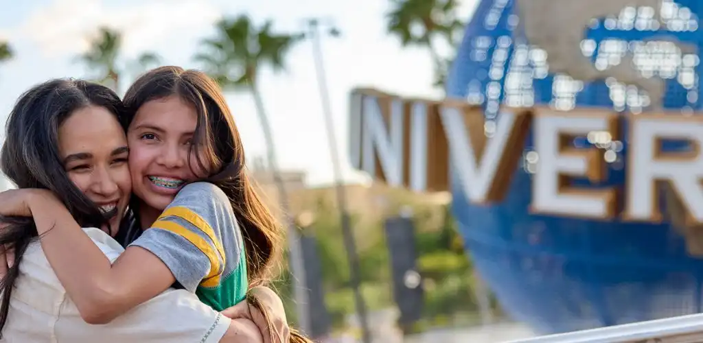Mother and daughter posing for a photo near the Universal Orlando globe.