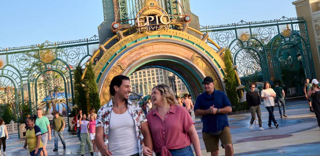 Crowd walking near the entrance of Universal Studios theme park with colorful gate and people enjoying the day