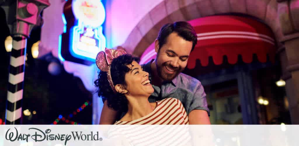 A couple smiling and sharing a magical moment under colorful neon lights during Disney’s Hollywood Studios After Hours