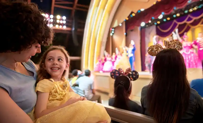 A mother and daughter watch in awe as a magical stage performance unfolds at Disney’s Hollywood Studios.