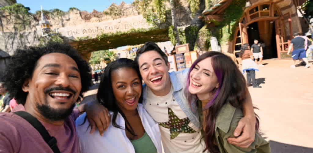 Group of friends smiling and taking a selfie at Universal’s Islands of Adventure entrance, ready for a day of thrilling rides and epic adventures.