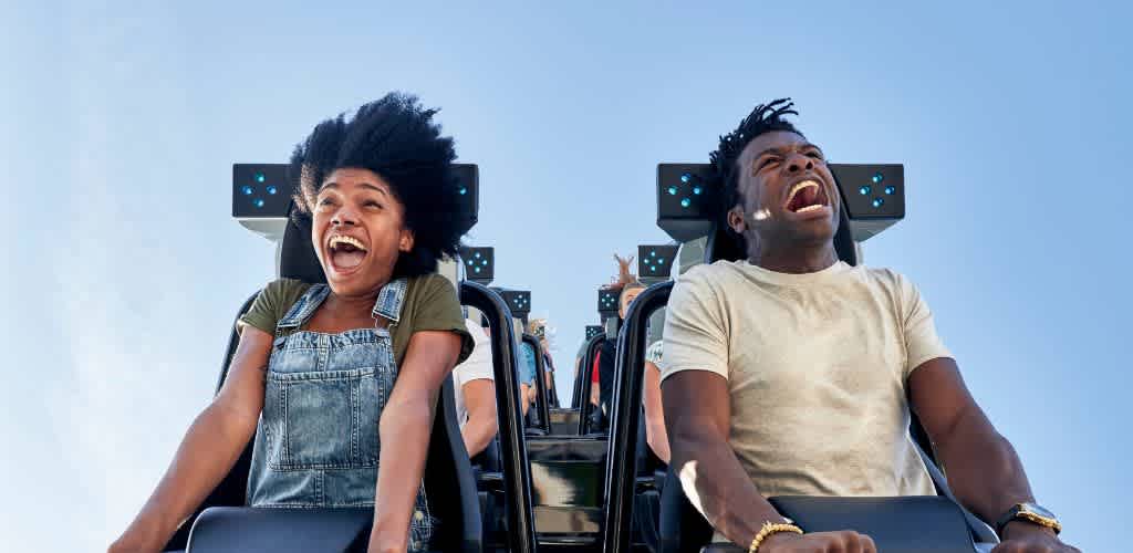 Guests screaming with excitement on a high-speed roller coaster at Universal Orlando Resort, experiencing heart-pounding drops and exhilarating twists.