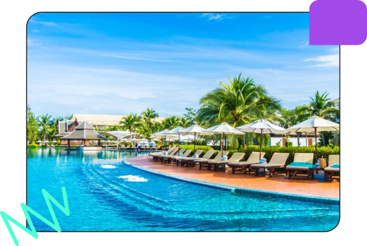 A luxurious outdoor pool area with lounge chairs, umbrellas, palm trees, and a clear blue sky, perfect for relaxation and leisure.